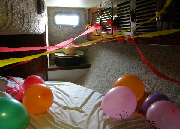 Balloons and streamers in the aft bedroom of a sailboat.