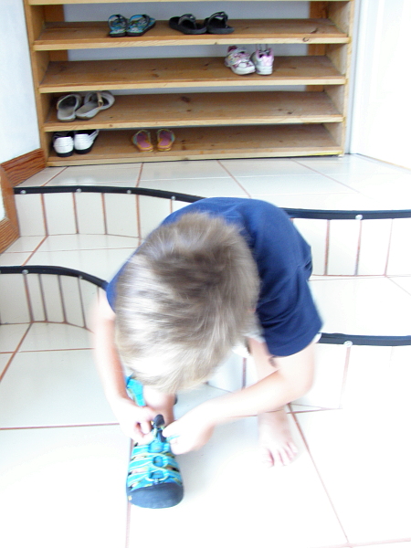 Boy putting on shoes.