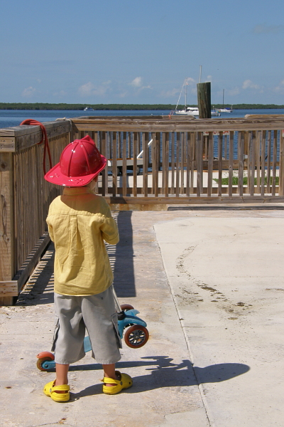 Boy with scooter and fireman's hat