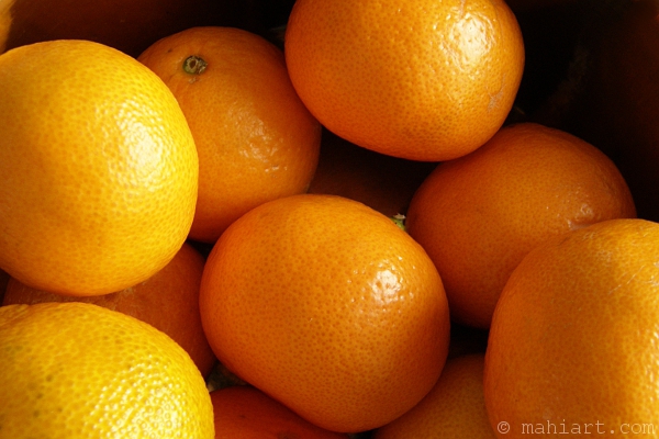 Bunch of tangerines in various shades of orange.