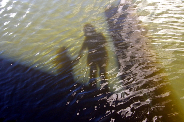 Shadows of mother and child on the water