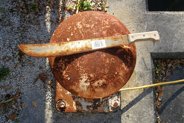 Rusty machete on rusty bollard.