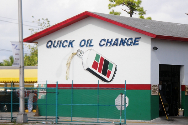 Mechanic shop building with depiction of large bottle of motor oil getting poured out.