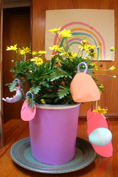 Flowering plant decorated with construction paper ornaments.
