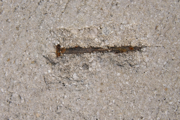 Rusty nail embedded in concrete