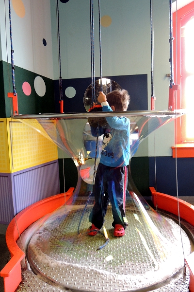Boy making a big soap bubble at children's museum
