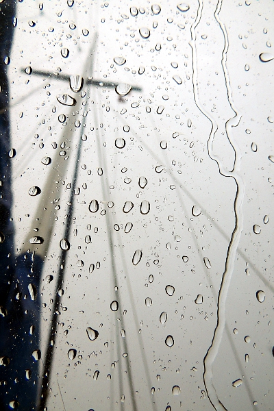 Sailboat mast as seen through rainy windscreen