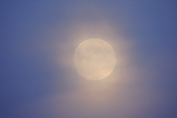 Full moon shining through clouds