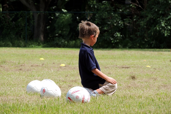 Boy sitting on soccer ball