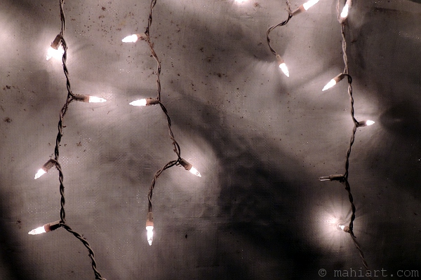 Christmas lights against weathered canvas