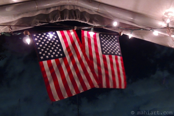 Two US flags hanging down from tent