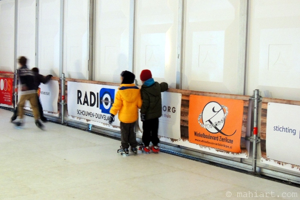 Boys learning to skate on artificial ice
