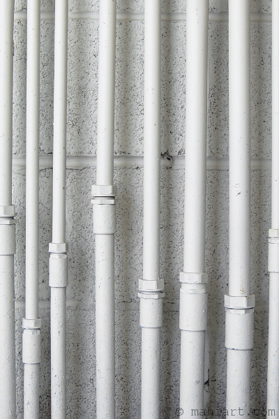 White pipes running along a white wall