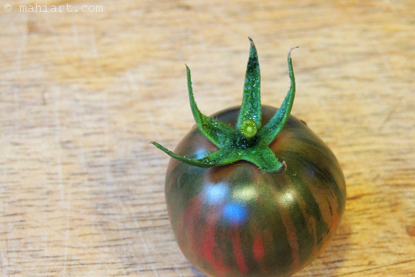 Closeup of small heirloom tomato on a cutting board